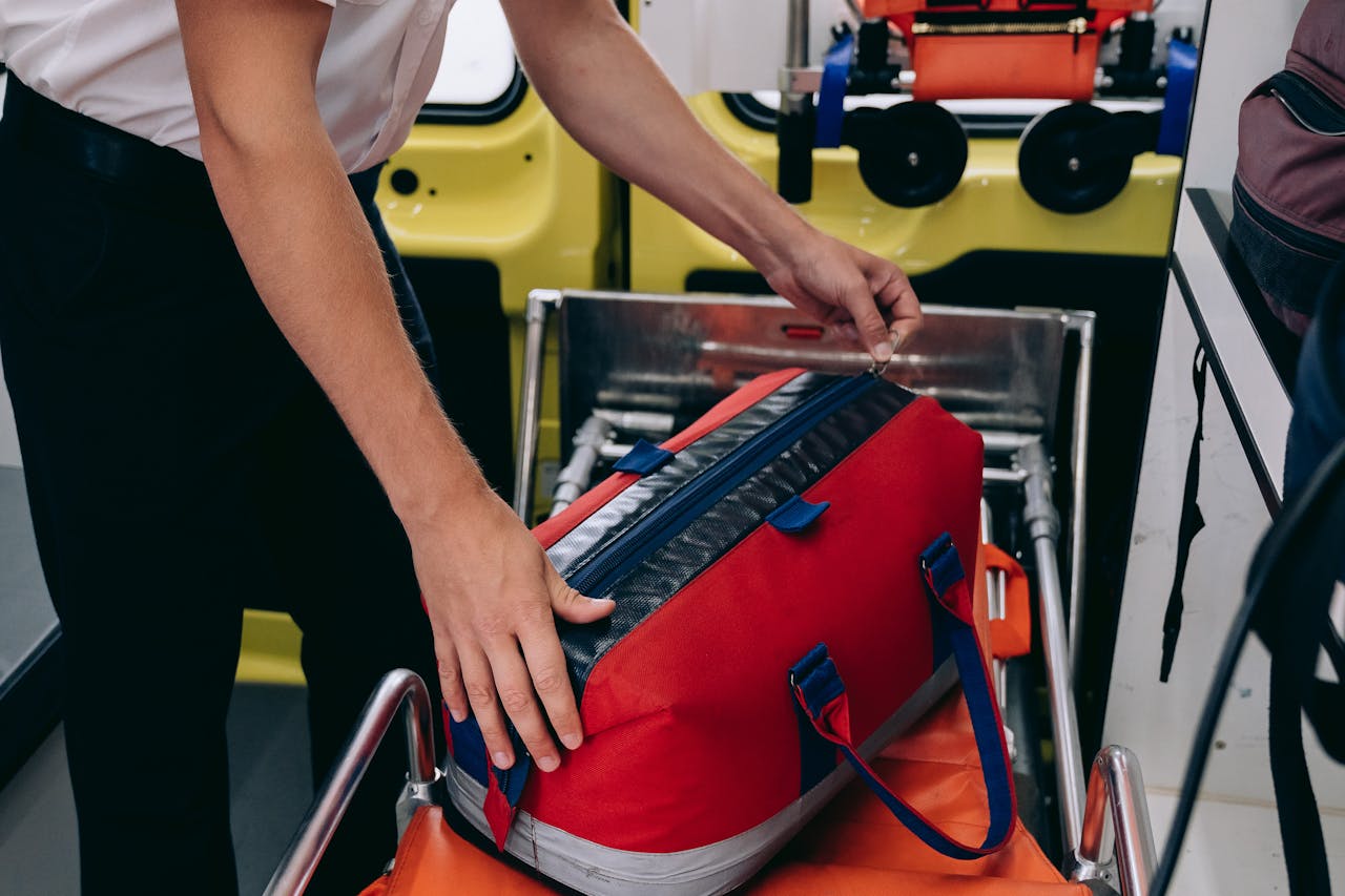 Paramedic organizing medical supplies inside an ambulance, ensuring readiness for emergency response.